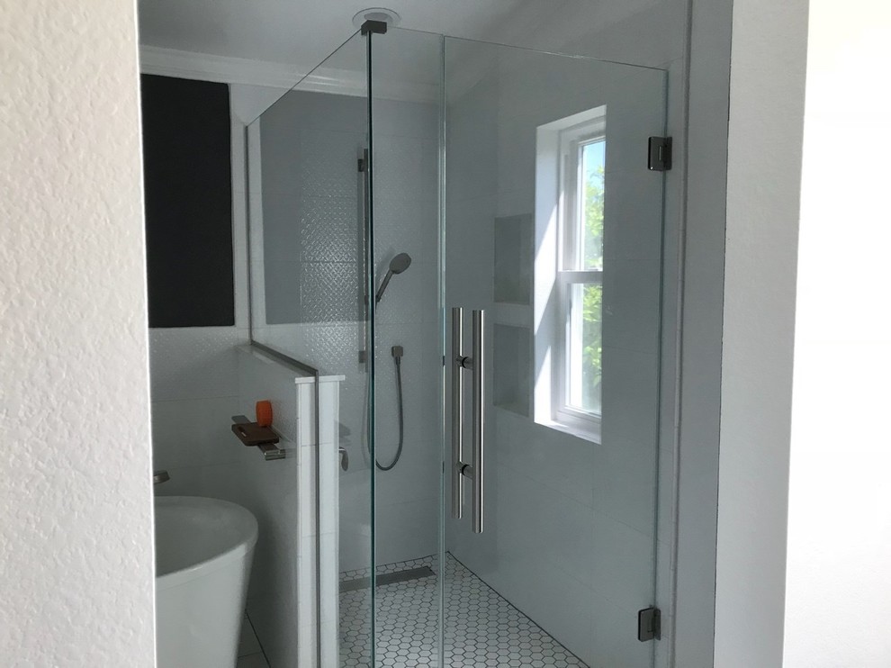 Пример оригинального дизайна: главная ванная комната в стиле модернизм с отдельно стоящей ванной, угловым душем, белой плиткой, черными стенами и белым полом