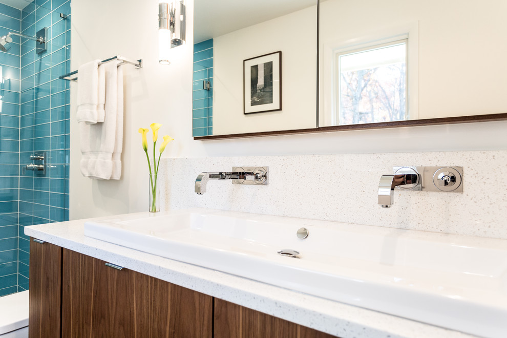 Mid-sized trendy master blue tile and glass tile porcelain tile alcove shower photo in New York with flat-panel cabinets, medium tone wood cabinets, a one-piece toilet, white walls, a drop-in sink and quartz countertops