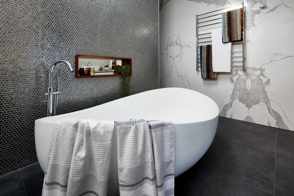 Idée de décoration pour une grande salle de bain principale design avec une baignoire indépendante, un carrelage gris, des carreaux de céramique, un mur blanc, un sol en carrelage de céramique et un sol gris.