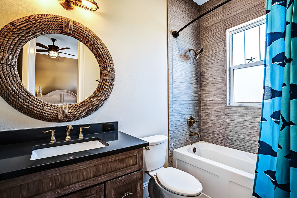 Example of a mid-sized transitional kids' gray tile and porcelain tile porcelain tile alcove bathtub design in Tampa with shaker cabinets, medium tone wood cabinets, a two-piece toilet, gray walls, an undermount sink and quartz countertops