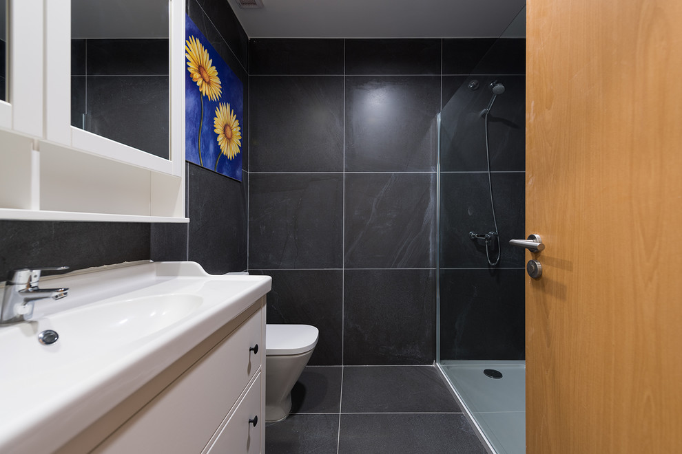 Mittelgroßes Modernes Badezimmer mit Toilette mit Aufsatzspülkasten, schwarzen Fliesen, schwarzer Wandfarbe, schwarzem Boden und weißen Schränken in Miami