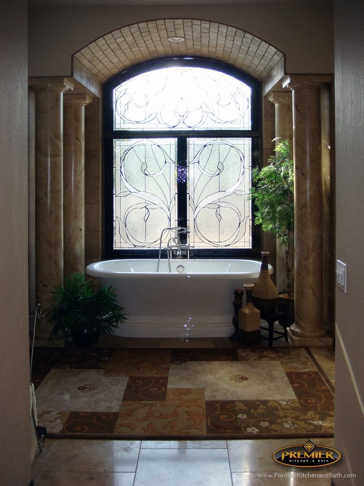Modelo de cuarto de baño principal mediterráneo grande con bañera exenta, baldosas y/o azulejos beige, baldosas y/o azulejos de piedra, paredes beige y suelo de travertino