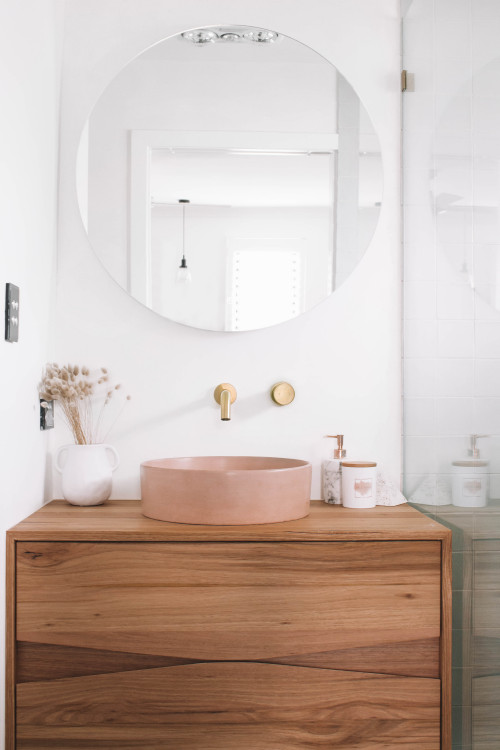brushed brass tapware with timber vanity and blush pink basin