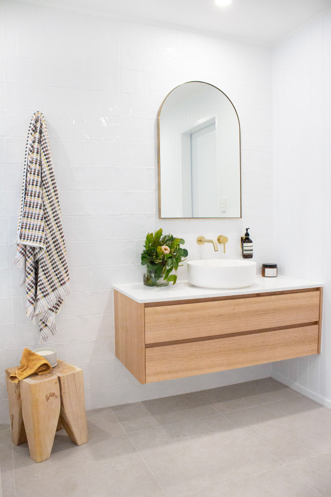 На фото: ванная комната в морском стиле с белой плиткой, серым полом, тумбой под одну раковину и подвесной тумбой
