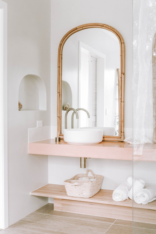 Pastel Perfection: Arched Bathroom Mirror Ideas, Pink Vanity, and Wood Shelf Delight