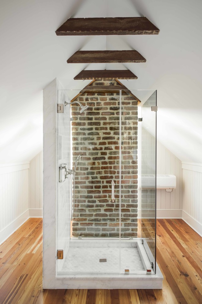Mid-sized urban master medium tone wood floor and brown floor alcove shower photo in Charleston with open cabinets, white walls, a wall-mount sink, a hinged shower door, gray cabinets and marble countertops