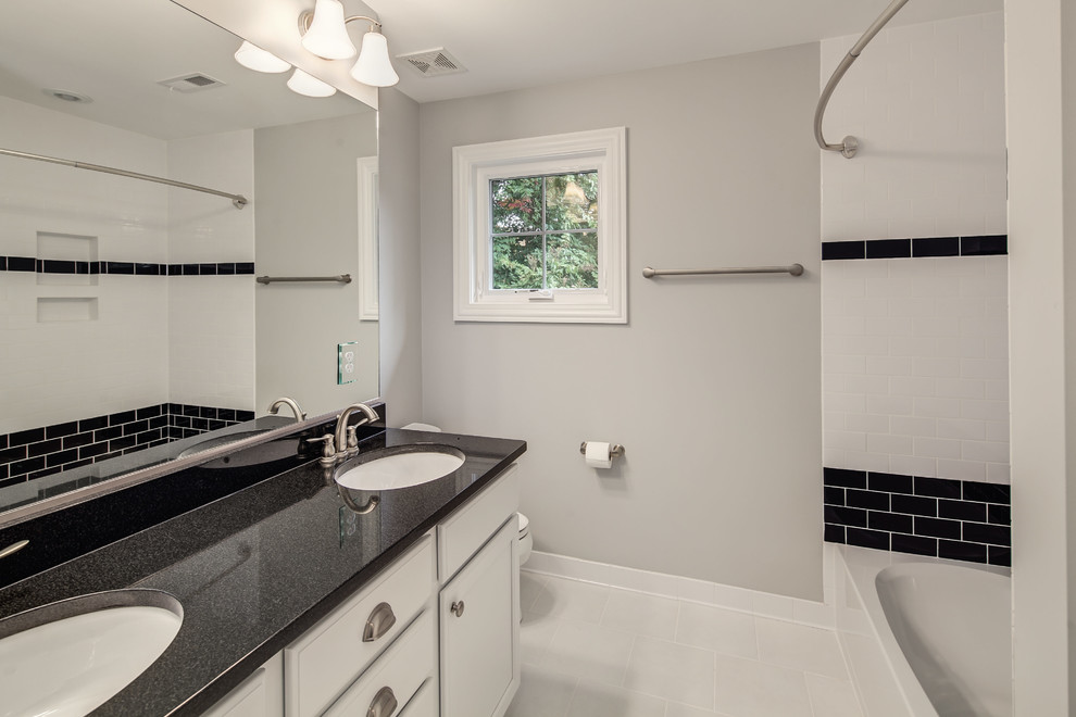 Идея дизайна: главная ванная комната среднего размера в стиле неоклассика (современная классика) с фасадами в стиле шейкер, белыми фасадами, ванной в нише, душем над ванной, черно-белой плиткой, плиткой кабанчик, серыми стенами и врезной раковиной