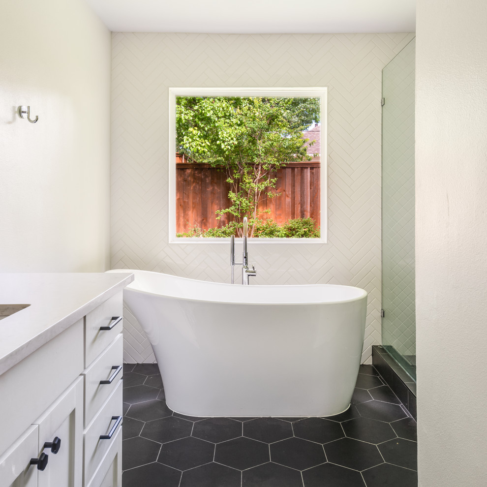 Freestanding bathtub - mid-sized transitional master white tile and porcelain tile porcelain tile and black floor freestanding bathtub idea in Dallas with shaker cabinets, white cabinets, white walls, an undermount sink, quartz countertops and white countertops