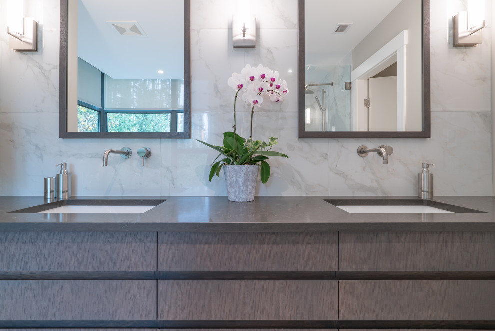 Modernes Badezimmer En Suite mit flächenbündigen Schrankfronten, freistehender Badewanne, Eckdusche, Toilette mit Aufsatzspülkasten, beiger Wandfarbe, Unterbauwaschbecken, Quarzit-Waschtisch, Falttür-Duschabtrennung und grauer Waschtischplatte in Vancouver
