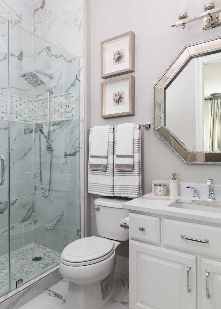 ヒューストンにあるトランジショナルスタイルのおしゃれな浴室 (レイズドパネル扉のキャビネット、白いキャビネット、白いタイル、グレーの壁、アンダーカウンター洗面器、グレーの床、白い洗面カウンター) の写真