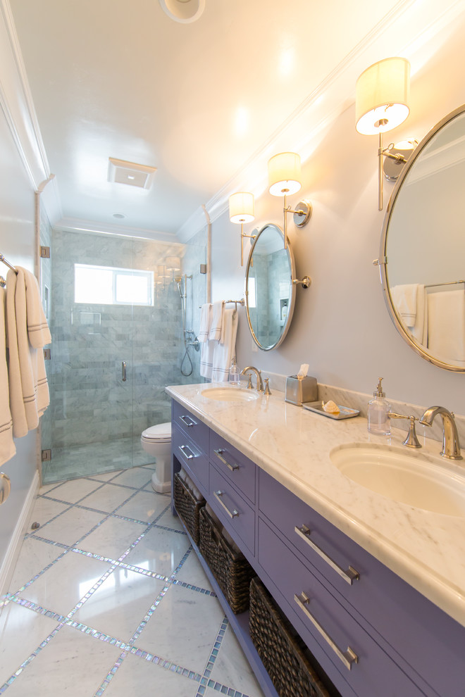 Foto di una stanza da bagno chic di medie dimensioni con lavabo sottopiano, ante lisce, top in marmo, doccia a filo pavimento, piastrelle in pietra, pareti blu e pavimento in marmo