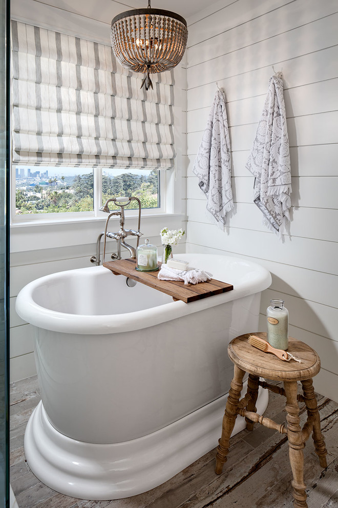 Ispirazione per una stanza da bagno padronale country con vasca freestanding, doccia ad angolo, piastrelle bianche, pareti bianche e pavimento in legno verniciato