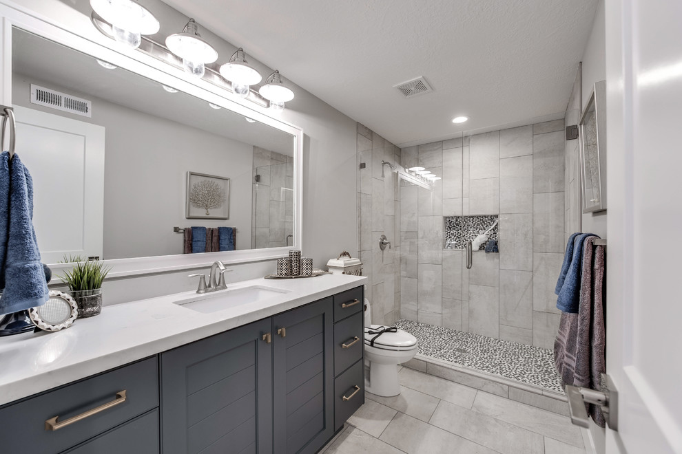 Идея дизайна: большая ванная комната в классическом стиле с фасадами с утопленной филенкой, синими фасадами, угловым душем, раздельным унитазом, серой плиткой, керамической плиткой, серыми стенами, полом из керамической плитки, душевой кабиной, врезной раковиной, столешницей из гранита, серым полом и шторкой для ванной
