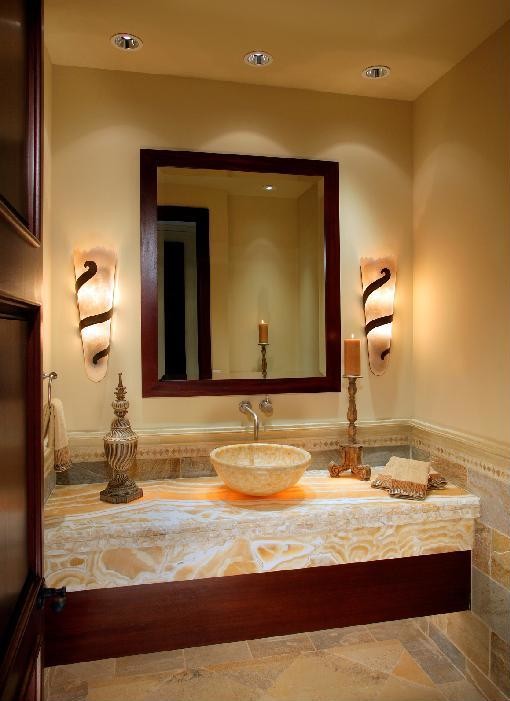 Photo of a large mediterranean bathroom in Orange County with open cabinets, dark wood cabinets, a two-piece toilet, multi-coloured tiles, stone tiles, beige walls, limestone flooring, a vessel sink and onyx worktops.