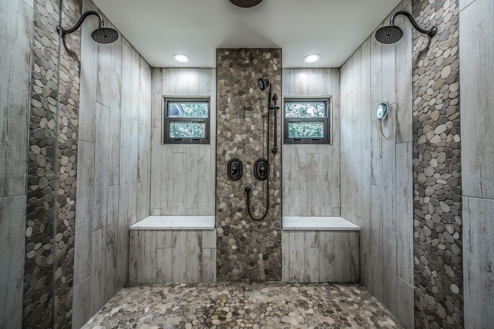 Пример оригинального дизайна: большая главная ванная комната в стиле рустика с фасадами с утопленной филенкой, темными деревянными фасадами, отдельно стоящей ванной, двойным душем, унитазом-моноблоком, серой плиткой, галечной плиткой, серыми стенами, полом из керамогранита, настольной раковиной, столешницей из искусственного кварца, белым полом и душем с распашными дверями