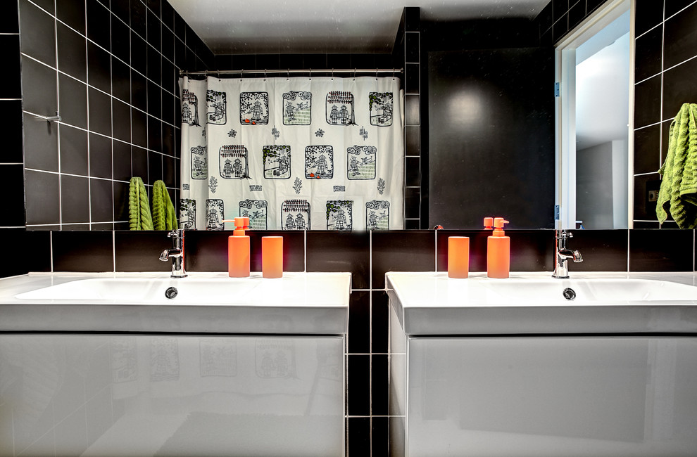 Photo of a medium sized contemporary family bathroom in Grand Rapids with flat-panel cabinets, white cabinets, a freestanding bath, a wall mounted toilet, grey tiles, stone tiles, white walls and an integrated sink.