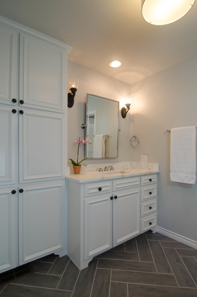 Foto på ett mellanstort vintage en-suite badrum, med ett undermonterad handfat, luckor med infälld panel, vita skåp, marmorbänkskiva, en dubbeldusch, en toalettstol med hel cisternkåpa, grå kakel, tunnelbanekakel, grå väggar och klinkergolv i porslin
