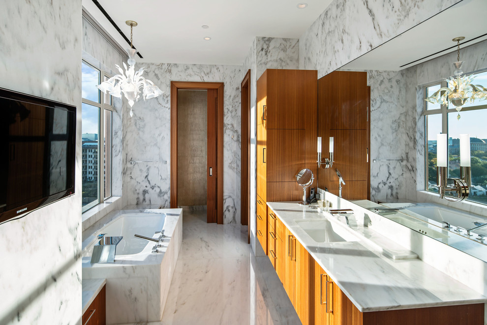 Bild på ett funkis vit vitt badrum, med släta luckor, skåp i mellenmörkt trä, ett undermonterat badkar, ett undermonterad handfat och vitt golv