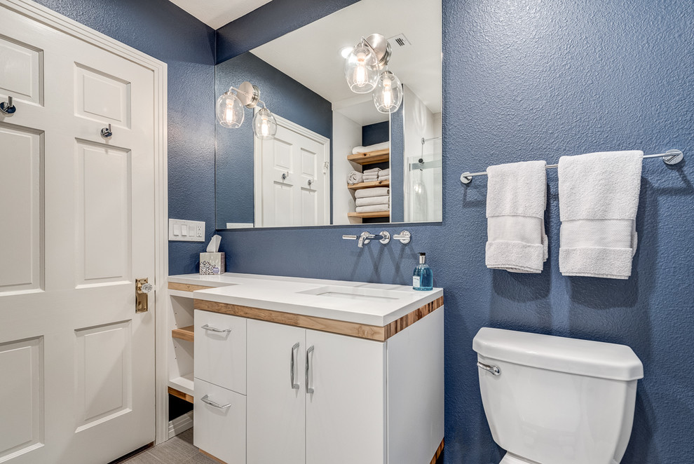 Пример оригинального дизайна: ванная комната в стиле неоклассика (современная классика) с плоскими фасадами, белыми фасадами, душем над ванной, белой плиткой, керамической плиткой, синими стенами, полом из керамогранита, врезной раковиной, бежевым полом и белой столешницей