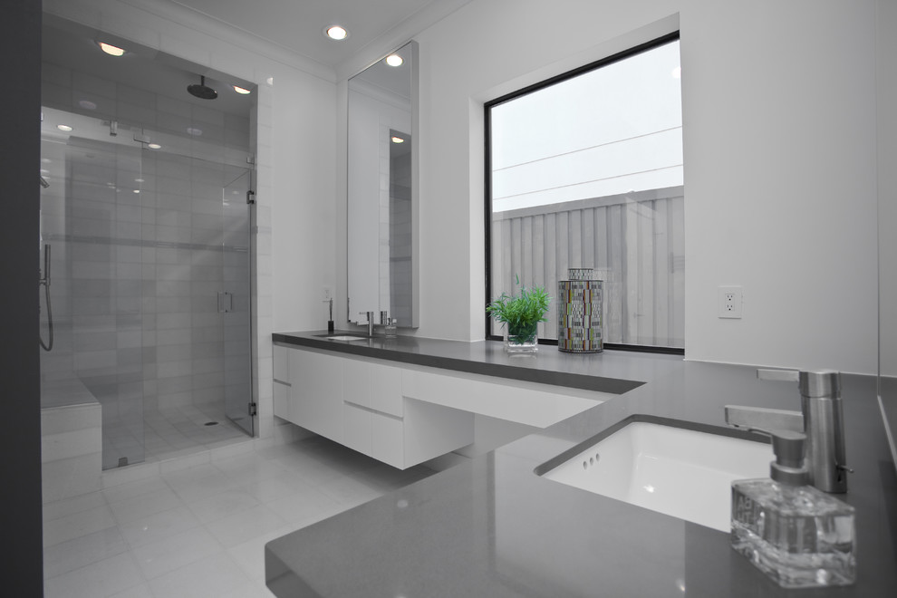 Inspiration for a contemporary grey and white bathroom in Dallas with a submerged sink, flat-panel cabinets, white cabinets, an alcove shower, white tiles and grey worktops.