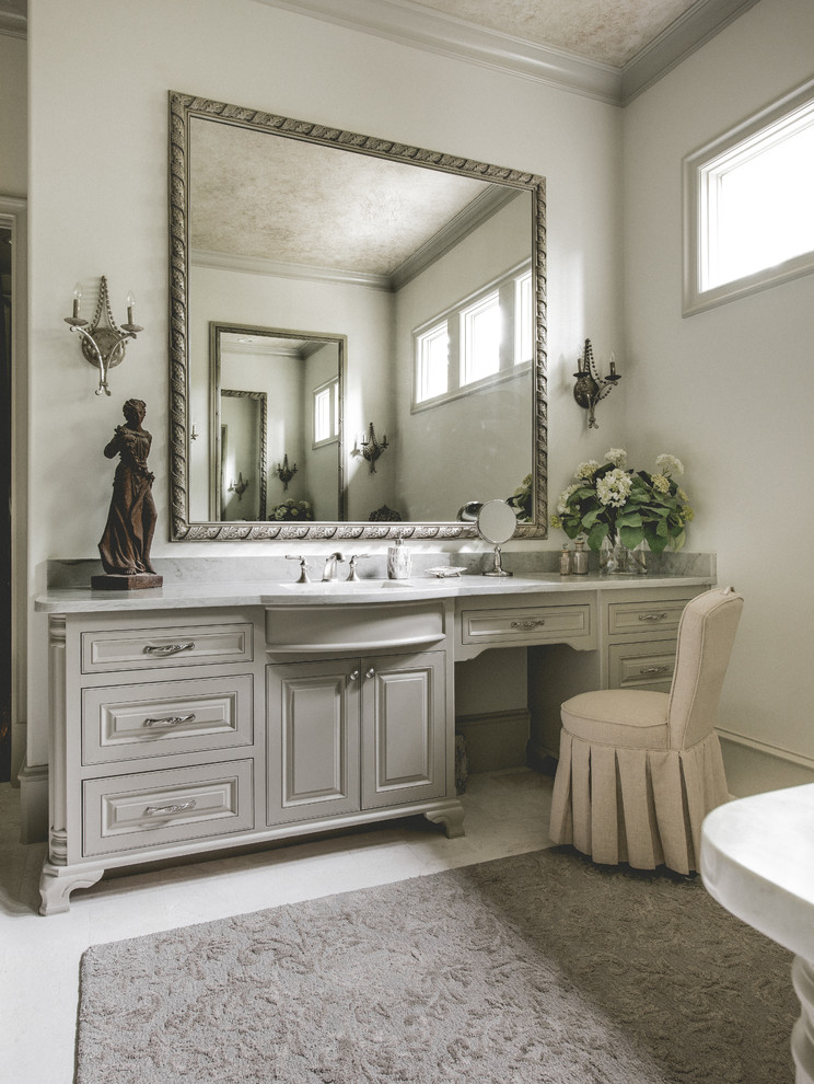 На фото: большая главная ванная комната в средиземноморском стиле с фасадами с выступающей филенкой, серыми фасадами, белыми стенами, мраморным полом и врезной раковиной с