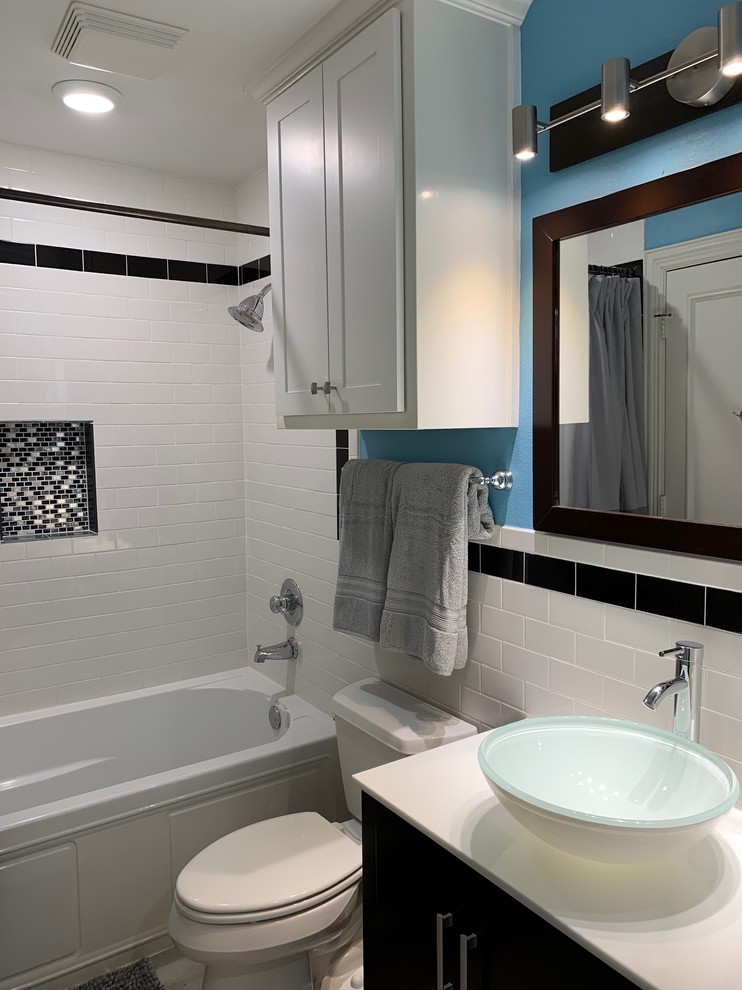 Example of a small minimalist kids' white tile and ceramic tile porcelain tile and gray floor drop-in bathtub design in Dallas with shaker cabinets, dark wood cabinets, a two-piece toilet, blue walls, a vessel sink, marble countertops and white countertops