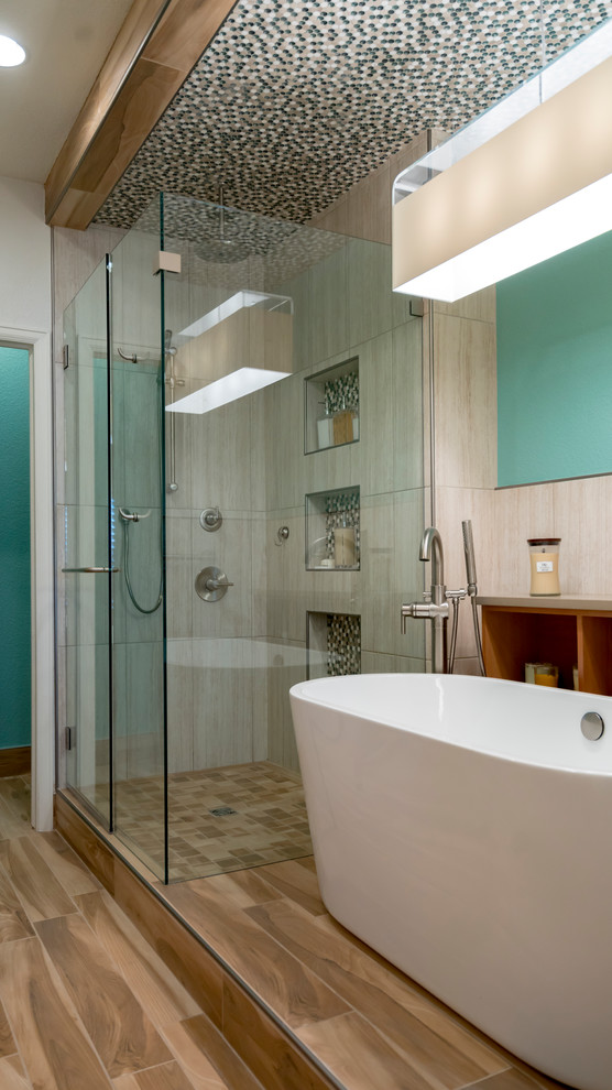 Inspiration for a medium sized contemporary ensuite bathroom in Denver with light wood cabinets, a freestanding bath, a corner shower, a two-piece toilet, beige tiles, ceramic tiles, green walls, ceramic flooring, a submerged sink, onyx worktops, brown floors and a hinged door.