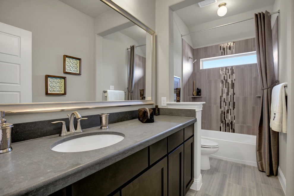 Exempel på ett stort klassiskt badrum för barn, med luckor med infälld panel, skåp i mörkt trä, ett badkar i en alkov, en dusch/badkar-kombination, grå kakel, glasskiva, grå väggar, linoleumgolv, ett undermonterad handfat, bänkskiva i akrylsten, grått golv och dusch med duschdraperi