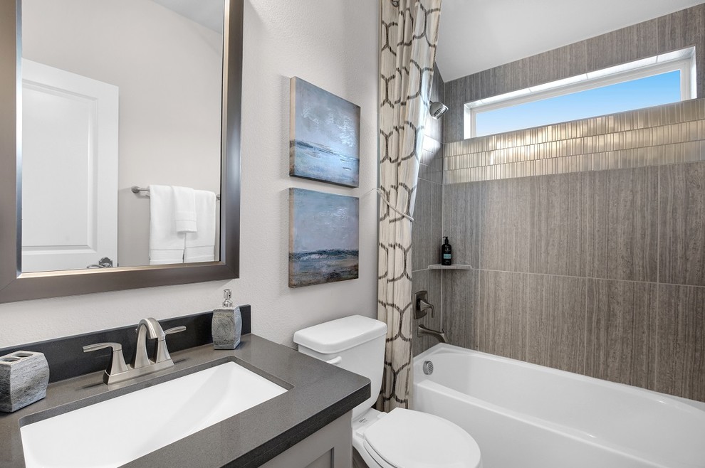 Medium sized contemporary family bathroom in Dallas with recessed-panel cabinets, grey cabinets, an alcove bath, a shower/bath combination, grey tiles, porcelain tiles, white walls, porcelain flooring, a submerged sink, limestone worktops, grey floors and a shower curtain.