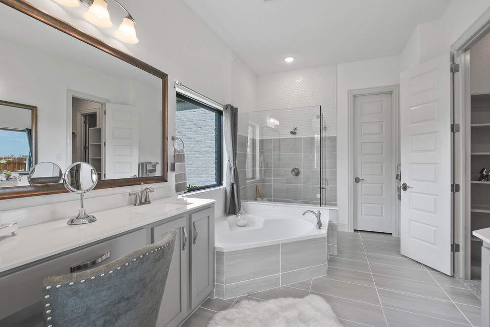 Design ideas for a medium sized contemporary ensuite bathroom in Dallas with recessed-panel cabinets, grey cabinets, a built-in bath, a corner shower, grey tiles, ceramic tiles, white walls, ceramic flooring, a submerged sink, solid surface worktops, grey floors, a hinged door and white worktops.