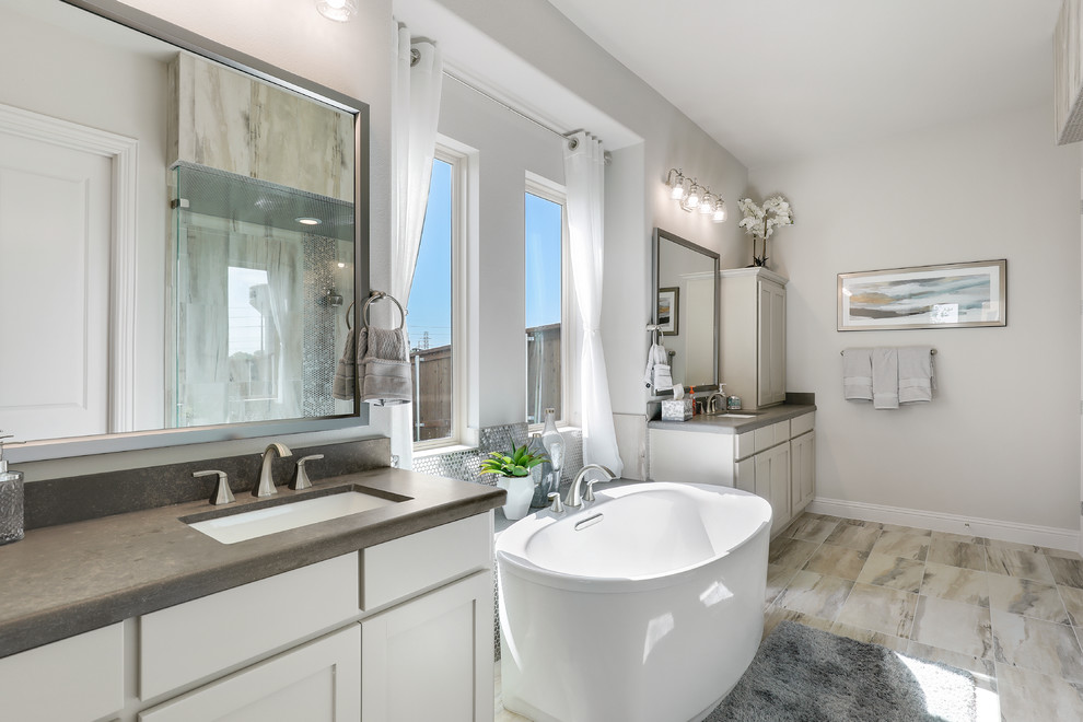 Bild på ett mellanstort vintage grå grått en-suite badrum, med grå skåp, ett fristående badkar, klinkergolv i keramik, ett undermonterad handfat, bänkskiva i akrylsten, skåp i shakerstil, grå väggar och flerfärgat golv