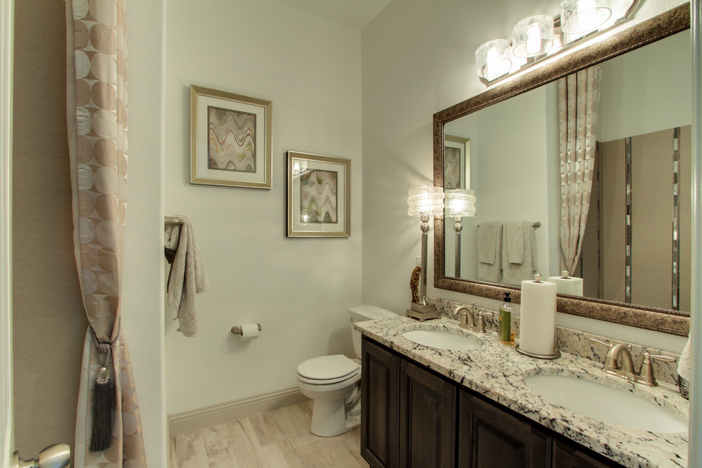 Example of a large classic 3/4 beige tile and glass tile laminate floor bathroom design in Dallas with raised-panel cabinets, white cabinets, white walls, an undermount sink and granite countertops