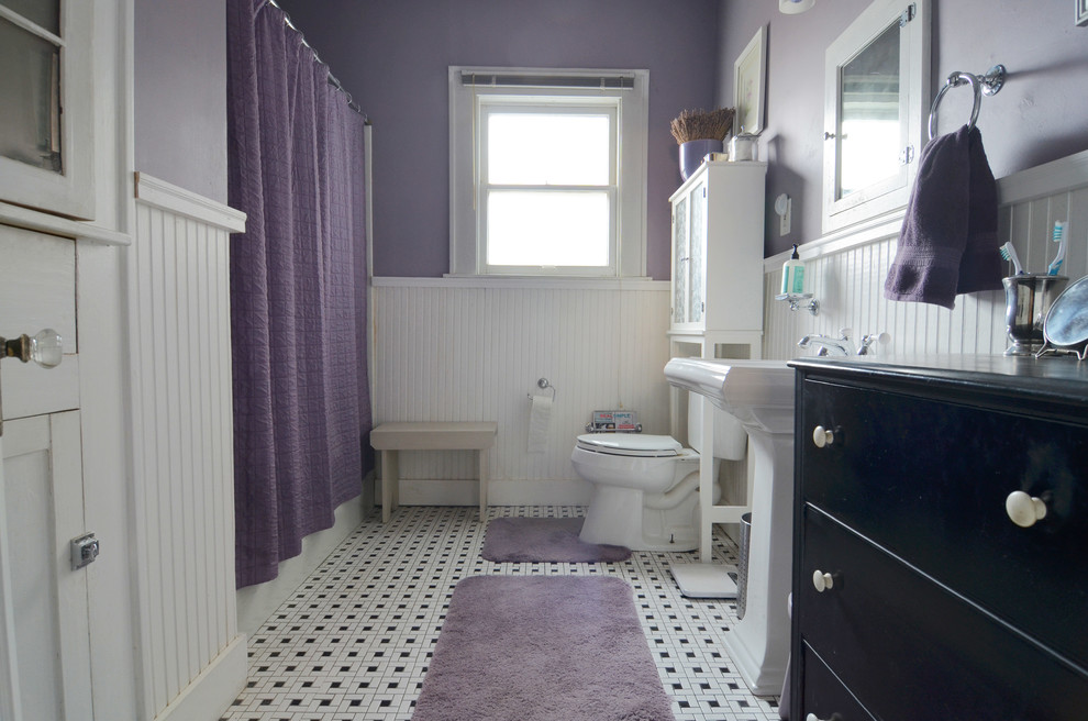 Inredning av ett klassiskt badrum, med svart och vit kakel och flerfärgat golv