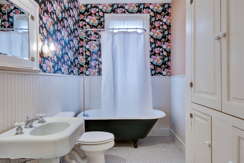 Foto på ett amerikanskt badrum för barn, med ett piedestal handfat, skåp i shakerstil, vita skåp, kaklad bänkskiva, ett badkar med tassar, en dusch/badkar-kombination, en toalettstol med hel cisternkåpa, vit kakel, stenkakel, rosa väggar och klinkergolv i porslin