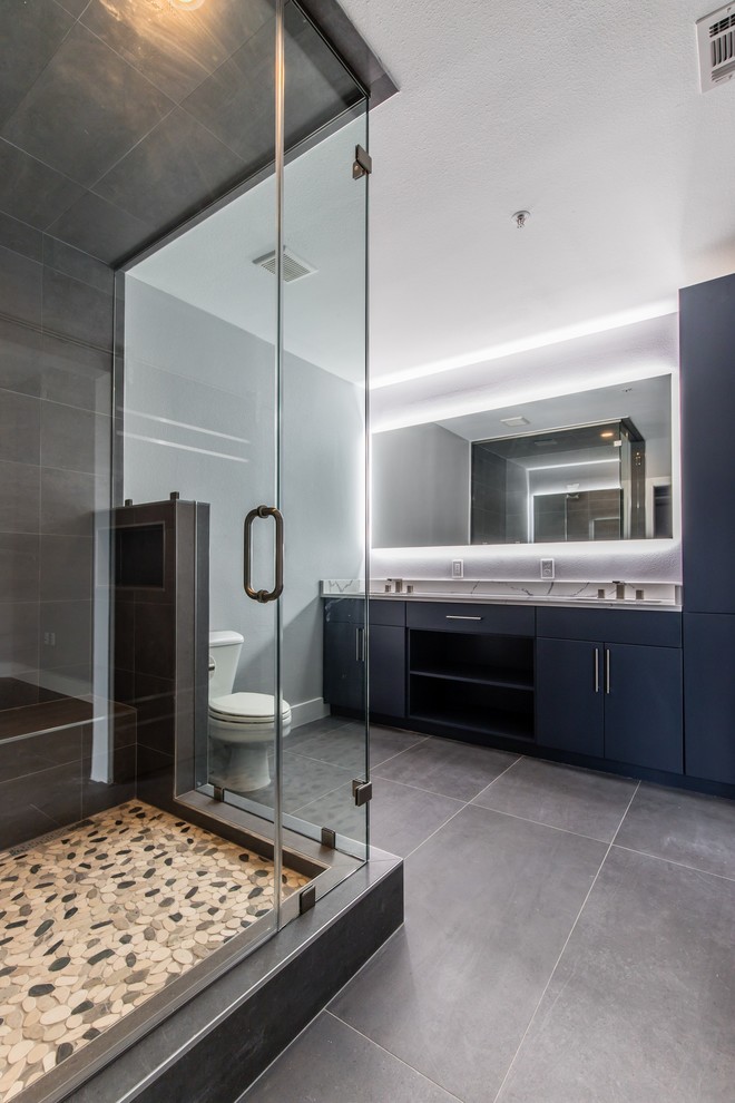 Design ideas for a medium sized modern ensuite wet room bathroom in Dallas with flat-panel cabinets, dark wood cabinets, grey tiles, porcelain tiles, white walls, porcelain flooring, a submerged sink, engineered stone worktops, grey floors, a hinged door and white worktops.