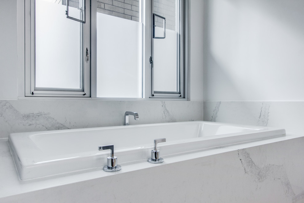 Foto di una stanza da bagno padronale minimal di medie dimensioni con ante lisce, ante grigie, vasca da incasso, pareti grigie, parquet chiaro, lavabo a bacinella, top in quarzo composito, pavimento beige e top bianco