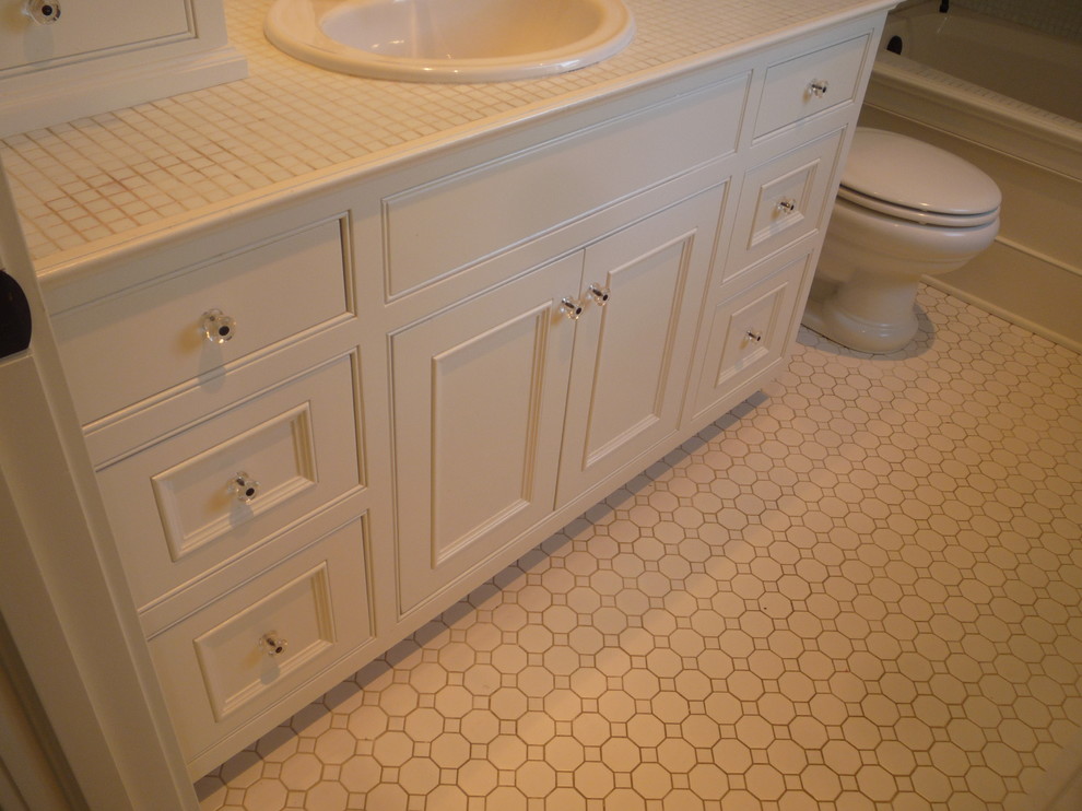 Bathroom - mid-sized farmhouse kids' white tile and glass tile mosaic tile floor bathroom idea in Orange County with a drop-in sink, recessed-panel cabinets, white cabinets, tile countertops, a two-piece toilet and white walls