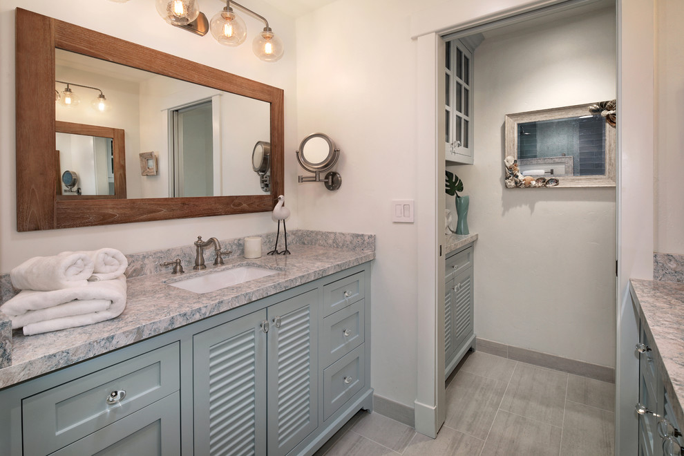 Example of a mid-sized beach style master blue tile and ceramic tile porcelain tile and gray floor bathroom design in Orange County with furniture-like cabinets, blue cabinets, a two-piece toilet, white walls, a drop-in sink, quartz countertops and multicolored countertops