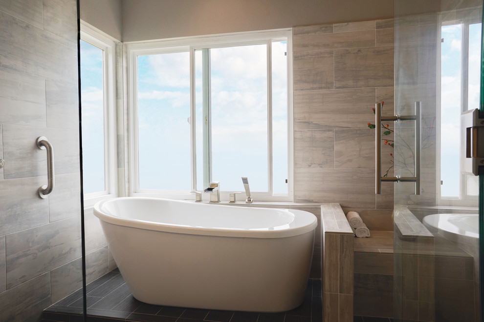 Design ideas for a medium sized modern ensuite wet room bathroom in Orange County with flat-panel cabinets, beige cabinets, a freestanding bath, a one-piece toilet, porcelain tiles, porcelain flooring, a built-in sink, engineered stone worktops, a hinged door, beige walls and grey floors.