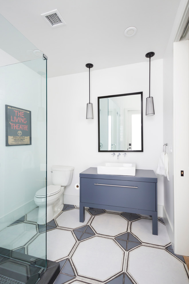 Foto på ett vintage badrum, med ett fristående handfat, släta luckor, blå skåp, en toalettstol med separat cisternkåpa och blå kakel