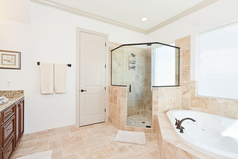 Large beach style master beige tile and stone tile travertine floor doorless shower photo in Orlando with an undermount sink, raised-panel cabinets, dark wood cabinets, granite countertops, an undermount tub, a one-piece toilet and white walls