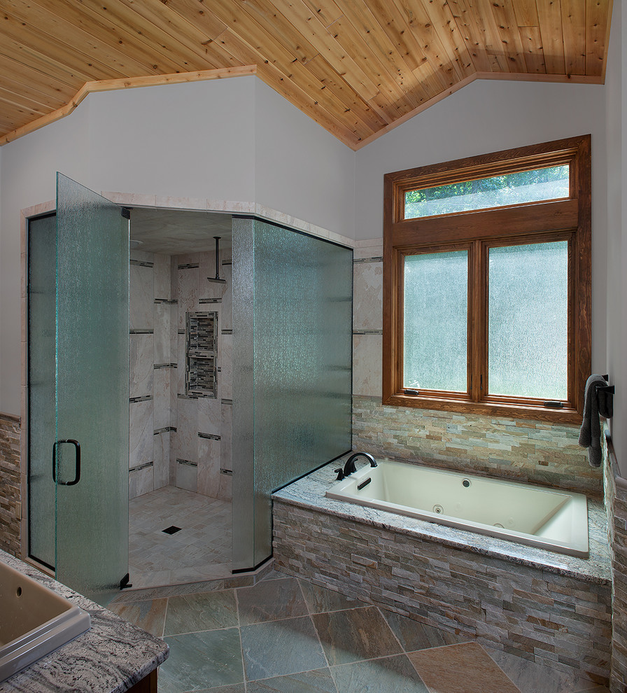 Design ideas for a large rustic ensuite bathroom in Grand Rapids with an alcove bath, an alcove shower, a two-piece toilet, grey tiles, stone tiles, grey walls, slate flooring, a built-in sink and granite worktops.