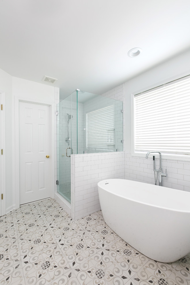 チャールストンにある高級な中くらいなカントリー風のおしゃれなマスターバスルーム (白いキャビネット、置き型浴槽、白いタイル、セラミックタイル、白い壁、セメントタイルの床、アンダーカウンター洗面器、グレーの床、開き戸のシャワー) の写真