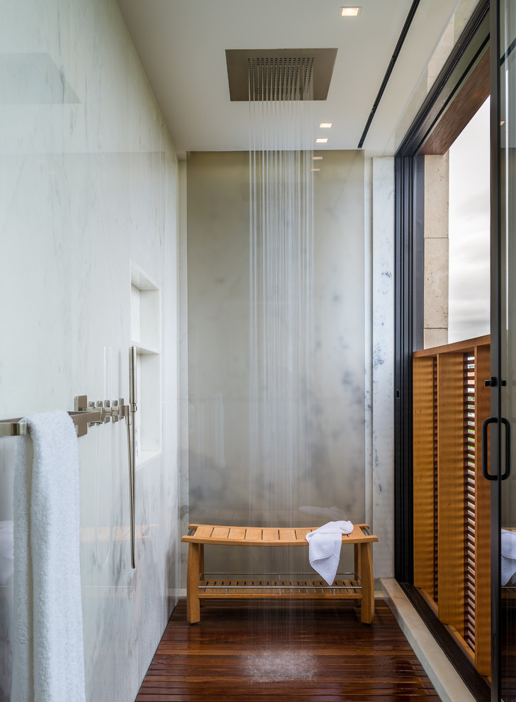 Idée de décoration pour une salle de bain design avec un carrelage beige, une niche et un banc de douche.