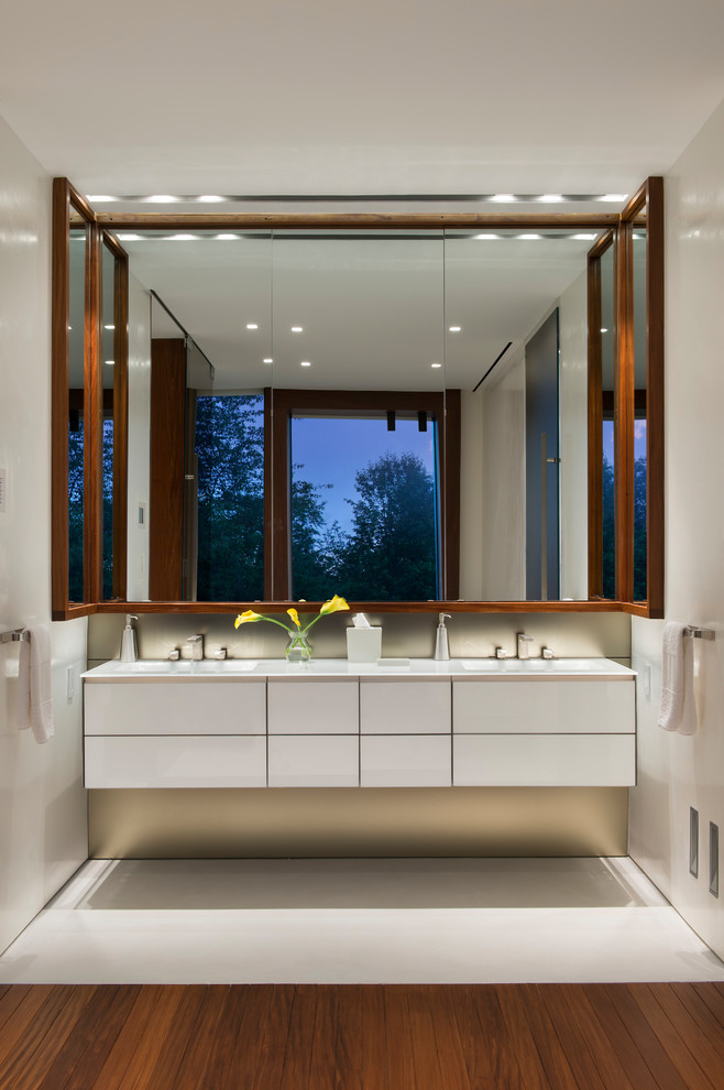 Ejemplo de cuarto de baño actual con armarios con paneles lisos, puertas de armario blancas y suelo blanco