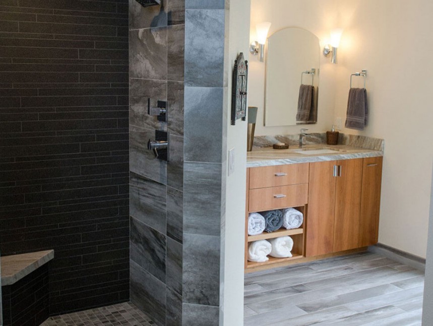 Ejemplo de cuarto de baño principal actual de tamaño medio con armarios con paneles lisos, puertas de armario de madera clara, ducha abierta, baldosas y/o azulejos grises, lavabo bajoencimera y encimera de madera