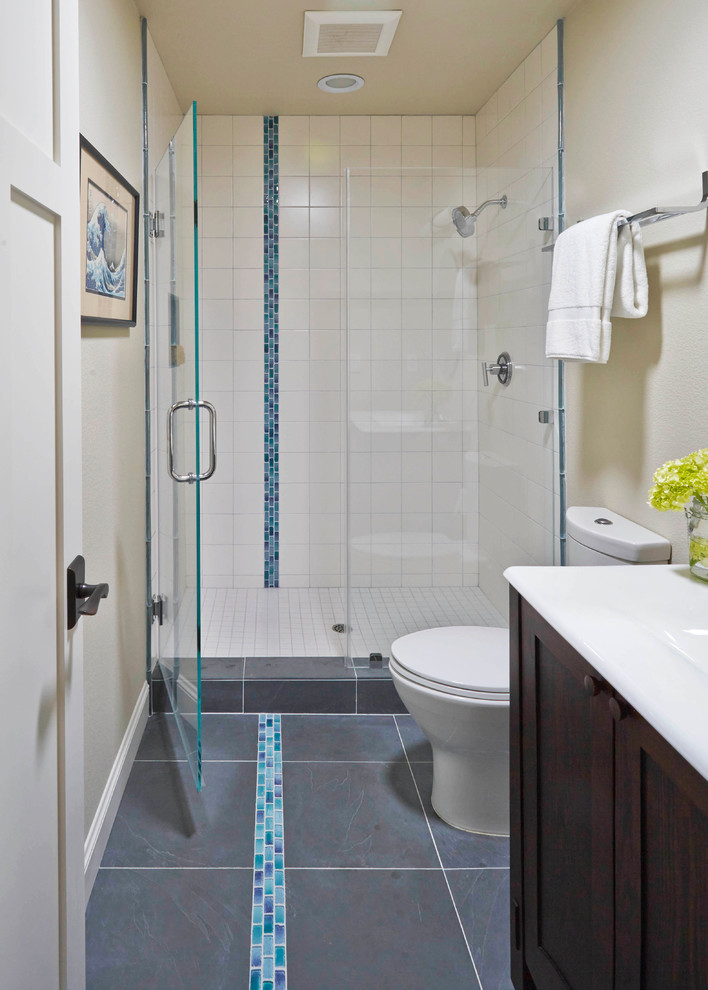 Inspiration for a small modern 3/4 white tile and porcelain tile slate floor alcove shower remodel in San Francisco with a console sink, recessed-panel cabinets, dark wood cabinets, solid surface countertops, a one-piece toilet and white walls