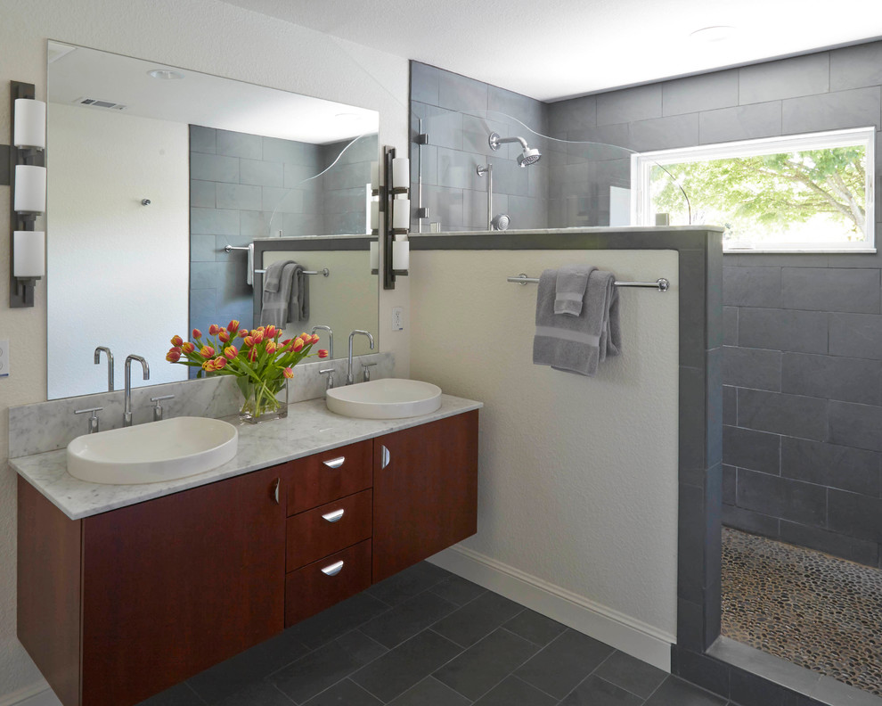 Inredning av ett modernt mellanstort en-suite badrum, med ett nedsänkt handfat, släta luckor, skåp i mörkt trä, en dusch i en alkov, grå kakel, stenhäll och vita väggar