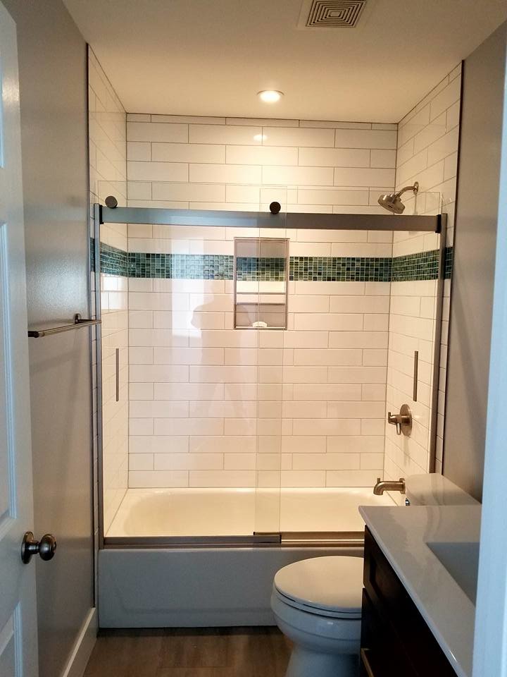 Design ideas for a small modern shower room bathroom in St Louis with flat-panel cabinets, dark wood cabinets, a built-in bath, a shower/bath combination, a one-piece toilet, grey walls, ceramic flooring, a pedestal sink, engineered stone worktops, grey floors, a sliding door and white worktops.
