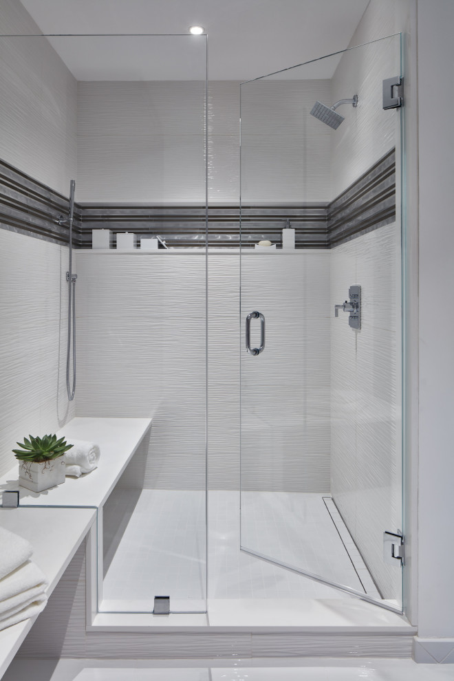 Пример оригинального дизайна: большая главная ванная комната в современном стиле с серыми фасадами, душем в нише, инсталляцией, белой плиткой, керамогранитной плиткой, белыми стенами, полом из керамогранита, врезной раковиной, столешницей из искусственного кварца, белым полом, душем с распашными дверями, белой столешницей, сиденьем для душа, тумбой под две раковины и подвесной тумбой
